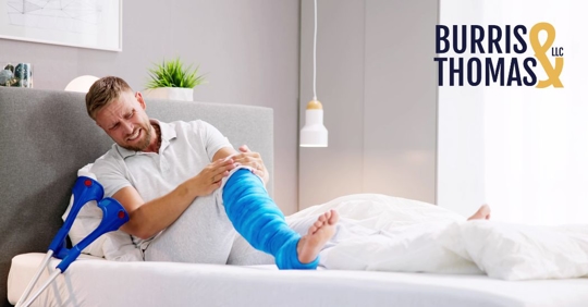 injured man lying in bed, wincing in pain